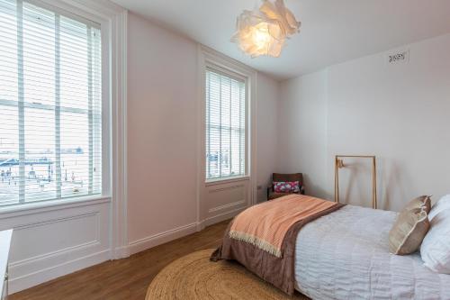 a bedroom with a bed and a large window at Harbour-View Apartment Facing HMS Warrior in Portsmouth