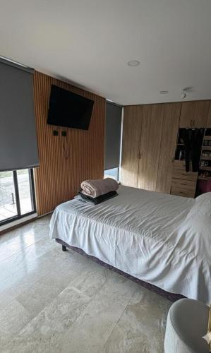 a bedroom with a bed and a flat screen tv at Residencia con alberca in Las Ánimas