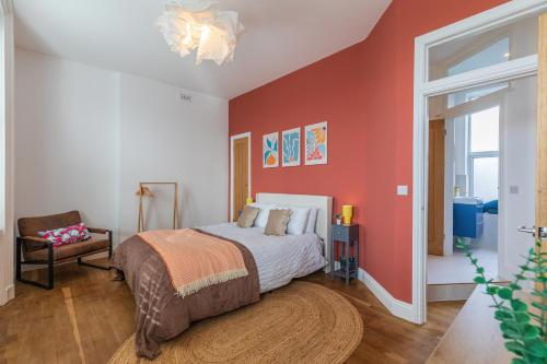 a bedroom with a bed and a red wall at Harbour-View Apartment Facing HMS Warrior in Portsmouth