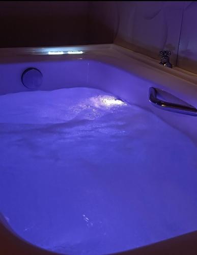 a bath tub with a blue light in it at Chalé Corina in Pirenópolis