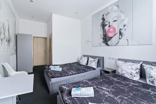 a room with two beds and a picture of a woman at 70s Business Room in Krakow