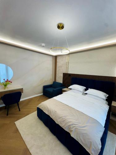 a bedroom with a large bed and a blue chair at Celeste Villa Boutique in Ranca
