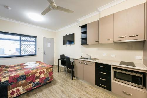 a room with a bed and a kitchen with a sink at Athena Studio Units in Roma