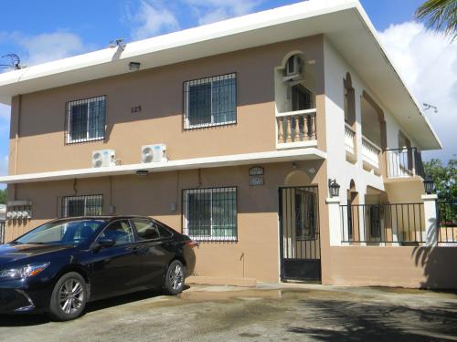 a black car parked in front of a house at Pedro Villas in Tamuning