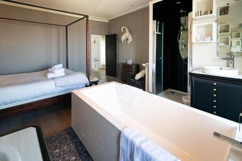 a bathroom with a large tub and a bed at Maison Valmer - L'armateur, élégant penthouse classé 4 étoiles in Le Havre