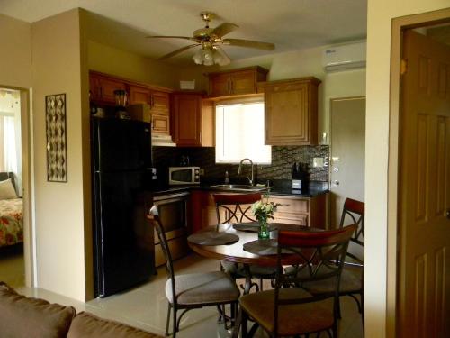 a kitchen with a table and chairs and a black refrigerator at Pedro Villas in Tamuning