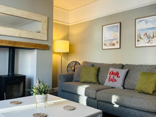 a living room with a couch and a table at Coast House Cromer - Sleeps 15, hot tub, sea views in Cromer