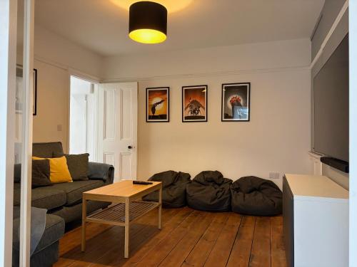 a living room with a couch and a table at Coast House Cromer - Sleeps 15, hot tub, sea views in Cromer