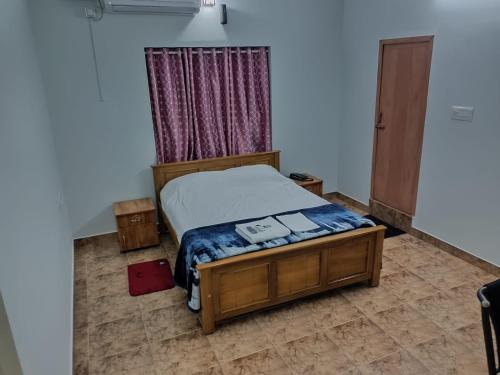 a bedroom with a bed and a window at Dwaraka Serviced Villa - Near Sree Padmanabha Swamy Temple, Trivandrum -AC Rooms & Parking in Trivandrum