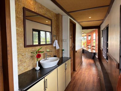 a bathroom with a sink and a mirror on the wall at Kera Houseboats Alleppey in Alleppey