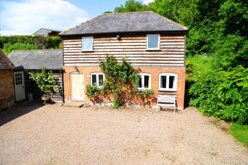 a house with a gravel driveway in front of it at Stable Cottage at Hanley Mill in Tenbury