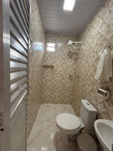 a bathroom with a toilet and a sink at pousada Bela Rosa in Santa Cruz Cabrália