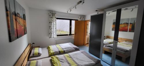a small room with two beds and a window at Ferienwohnung Vogelsang in Sachsenheim