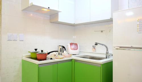 a kitchen with green cabinets and a sink at Pinky Marine Pension in Namhae