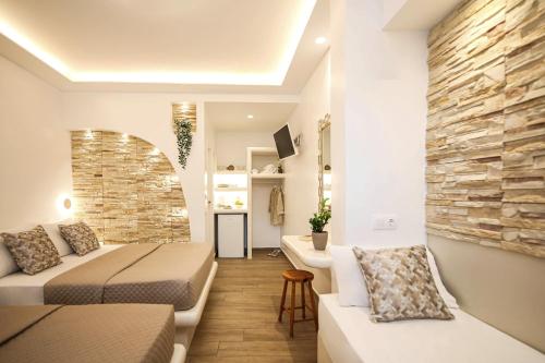 ein Wohnzimmer mit Sofa, Bett und Waschbecken in der Unterkunft Augusta Studios & Apartments in Naoussa