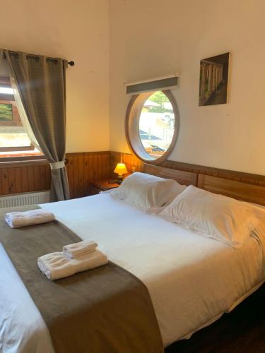 a bedroom with a large bed with two towels on it at HOTEL & HOSTAL CHIL'IN, Las Trancas in Las Trancas