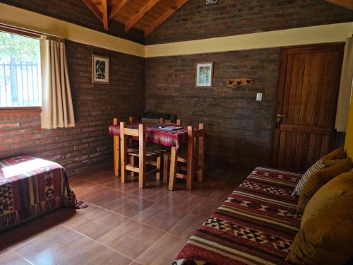 a room with a table and chairs in a room at Cabañas Bosque Andino con hidromasaje in Esquel