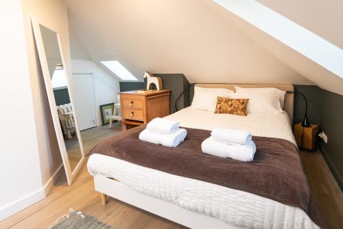 a bedroom with a bed with two towels on it at Maison Valmer - Le négociant, élégant F2 classé 4 étoiles in Le Havre