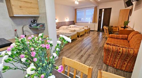 a living room with a couch and tables and flowers at Pod Kasztanem in Świnoujście
