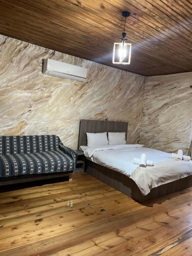 a bedroom with a bed and a couch in it at Harmony Guest House in Ijevan
