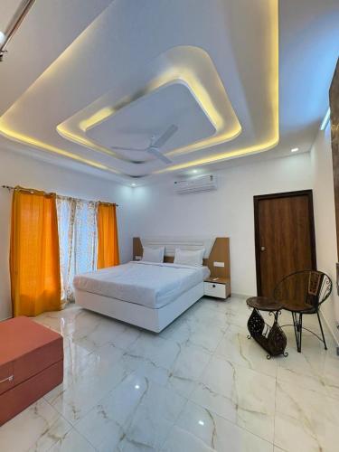a bedroom with a white bed and a largevisor at Casa Aura Villa in Udaipur