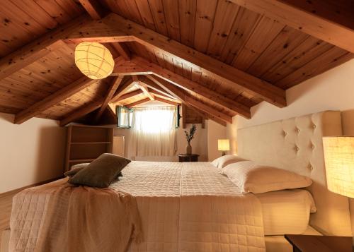 a bedroom with a large bed in a room with wooden ceilings at Joya Luxury Villas in Kypseli