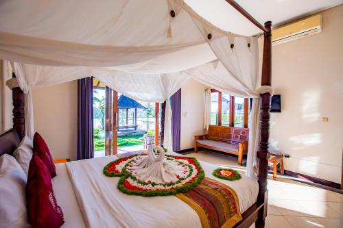 a bedroom with a bed with a flower arrangement on it at Warung Mandi & Villa in Ubud