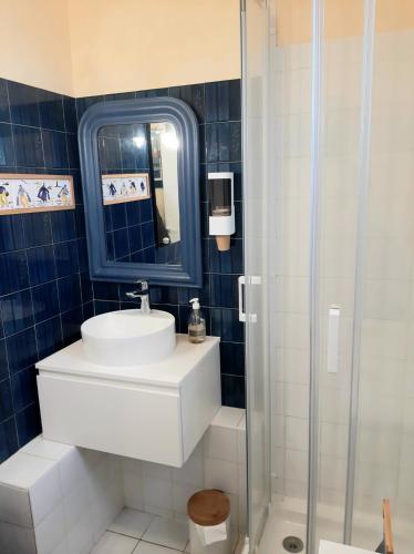 une salle de bains avec lavabo et douche en verre dans l'établissement Rigadell, à Penmarcʼh