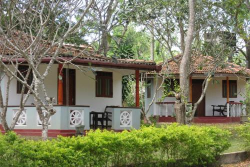 ein kleines weißes Haus mit rotem Dach in der Unterkunft Calm Garden Cabanas in Tangalle