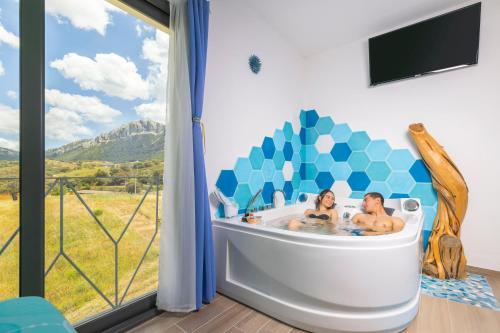 a couple in a bath tub in a room with a window at Agua Dorada Retreat in Lula