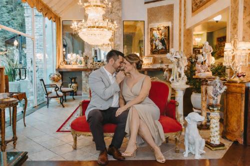 a bride and groom sitting on a chair in a room at Le Boutique Hotel Gramado - Exclusivo para Casais in Gramado
