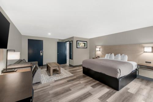 a hotel room with a bed and a flat screen tv at Red Lion Inn & Suites Kansas City in Kansas City