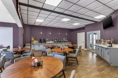 a restaurant with tables and chairs and a kitchen at Cambridge Hotel - Kansas City in Kansas City