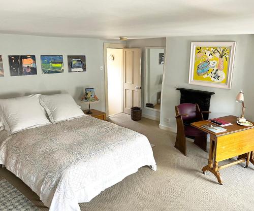 a bedroom with a bed and a desk and a chair at The Artist's House in Norwich