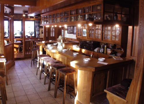 eine Bar in einem Restaurant mit Holztischen und Hockern in der Unterkunft Landgasthof Kaiser in Bad Wünnenberg