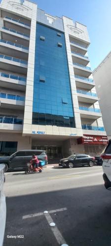 a large building with cars parked in front of it at Universe Holiday Homes Burjuman in Sabkhah