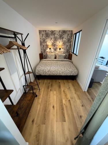 a bedroom with a bed in a room with wooden floors at Ocean Lodge Seignosse in Seignosse