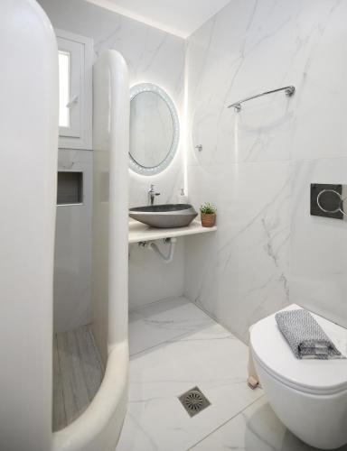 ein weißes Badezimmer mit Waschbecken und Toilette in der Unterkunft Augusta Studios & Apartments in Naoussa