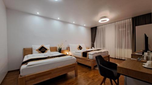 a hotel room with two beds and a desk at Apartmány Farní in Moravská Třebová