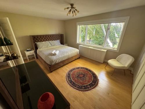 a bedroom with a bed and a window and a chair at Spacious 4-Bedrooms Friendly House-Pool-Parking in Markham