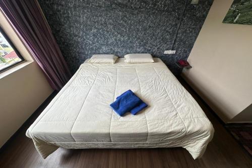 a bedroom with a bed with a blue pillow on it at Hotel Titiwangsa in Brinchang