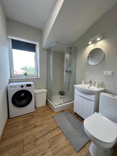 a bathroom with a shower toilet and a washing machine at Mieszkania od 32-55m, pełne wyposażenie, komfortowe warunki in Stanisławów Pierwszy