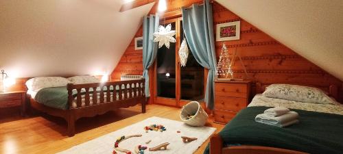 a bedroom with two twin beds and a staircase at Chata Ku Tatrom in Biały Dunajec