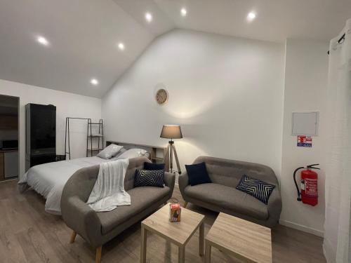 a bedroom with a bed and a couch and a chair at Un cocoon spacieux in Les Essarts-le-Roi