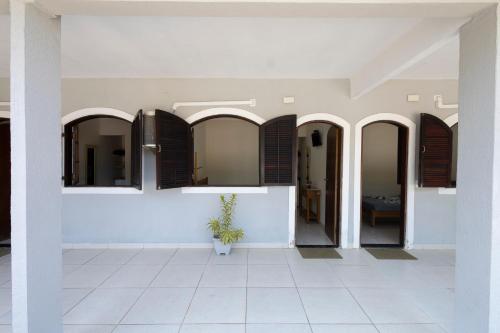 a hallway of a house with windows and a tile floor at Pousada da Árvore in Boicucanga