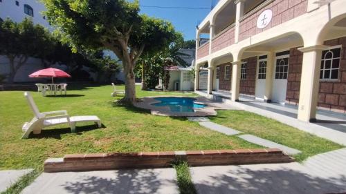 a building with a pool in the yard at Hotel de la Cruz in Maguey Blanco