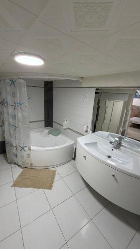 a white bathroom with a tub and a sink at Casa Della Felicità in Naples