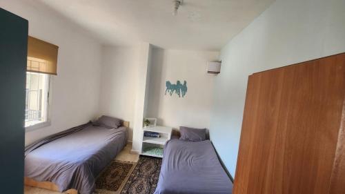 a bedroom with two beds and a window at Z House Jbeil in Jbeil