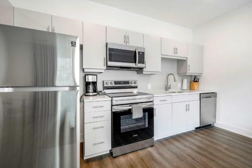 a kitchen with white cabinets and stainless steel appliances at King Studio Getaway! Prime Location, Balcony, Gym - S2 in Atlanta