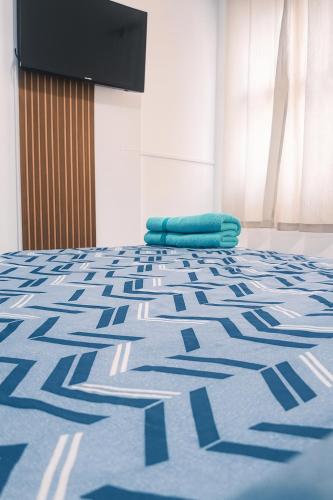a bed with a blue pillow on top of it at Kit net a poucos passos do mar in São Vicente